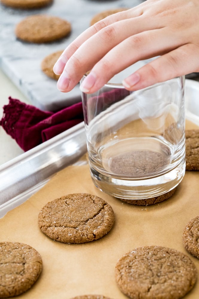 Making gingersnap cookies: Flattening freshly baked cookies by pressing with the bottom of a glass