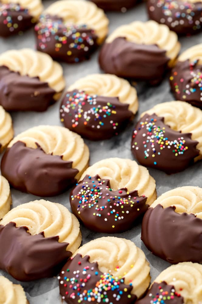 Butter cookies that have been dipped in chocolate and sprinkled with colored nonpareils