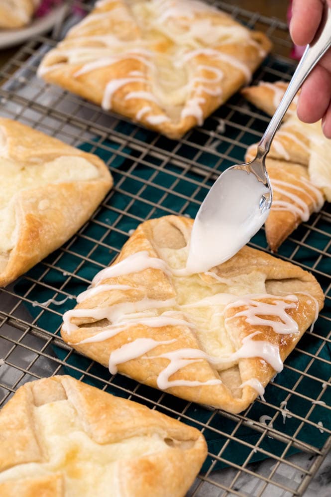 Drizzling glaze over freshly baked cheese danish