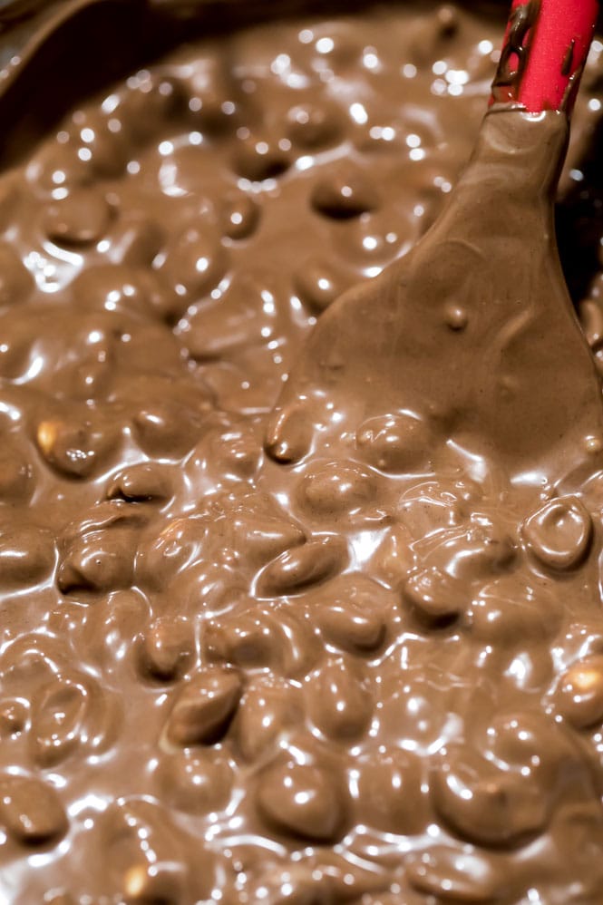 Peanuts in melted chocolate with spatula