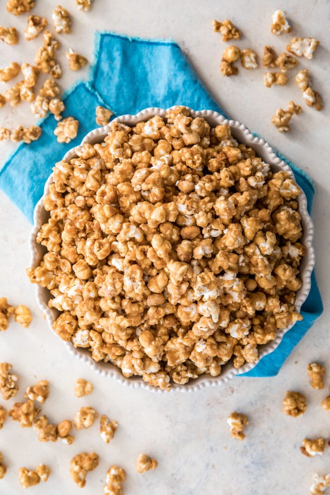 Caramel popcorn in a white dish on a blue towel