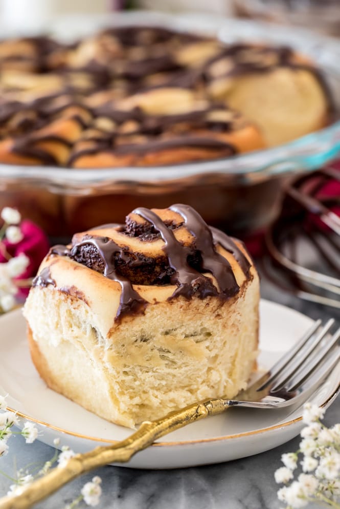 Chocolate roll with chocolate glaze on a white plate