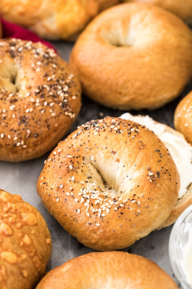 bagels on marble with one cut in half with cream cheese