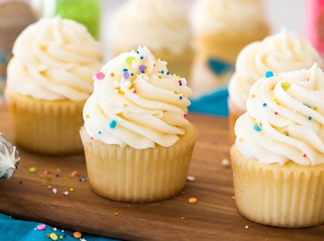 Buttercream frosting topped with sprinkles on vanilla cupcake
