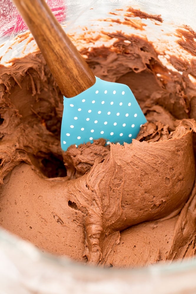 chocolate frosting in glass bowl with spatula
