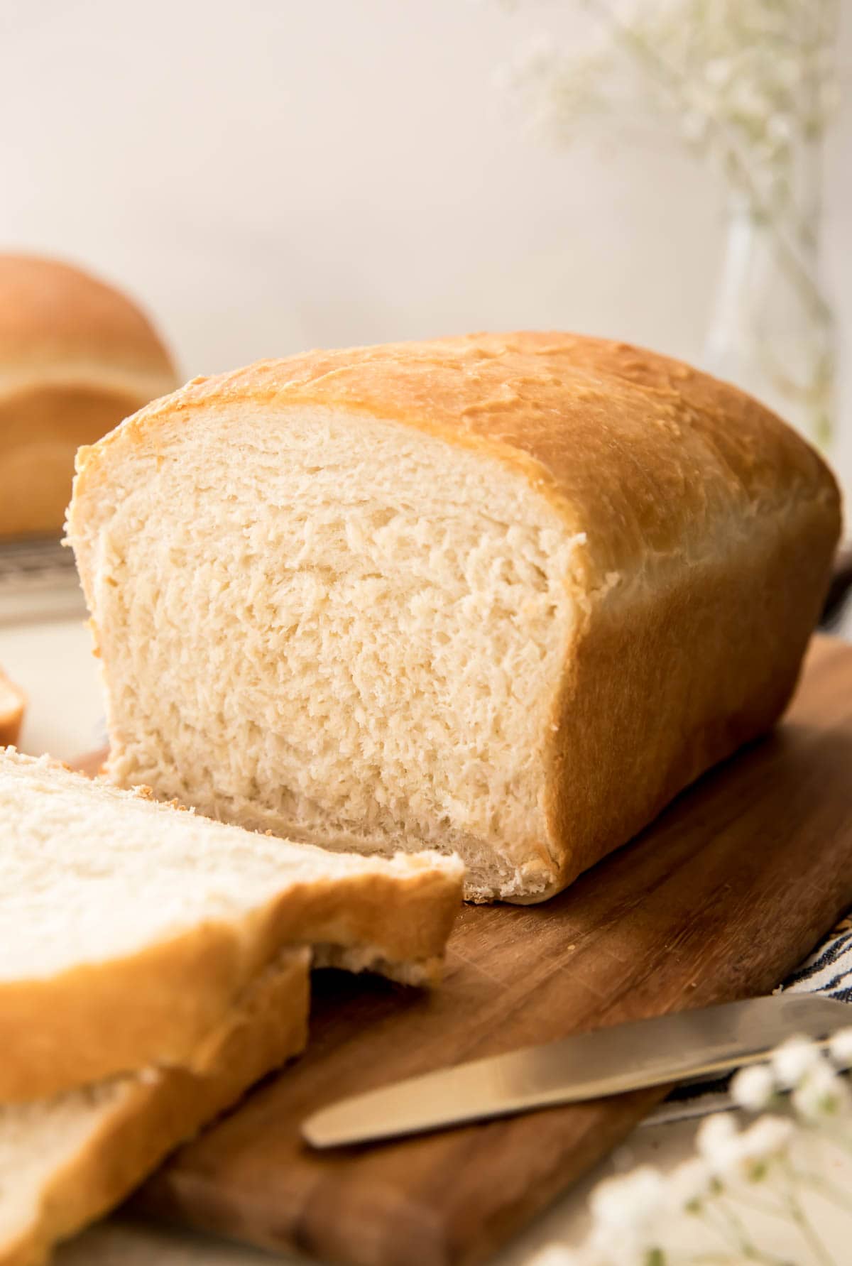 loaf of bread on cutting board with slices cut in front of it