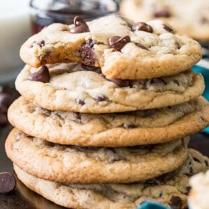 Stack of cookies made from this chocolate chip cookie recipe with melty chocolate chips and a bite missing from the top cookie