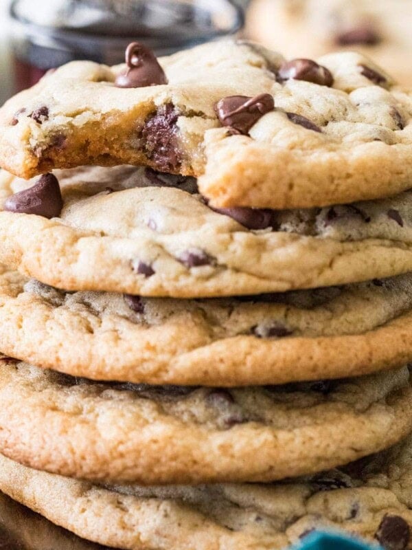Stack of cookies made from this chocolate chip cookie recipe with melty chocolate chips and a bite missing from the top cookie