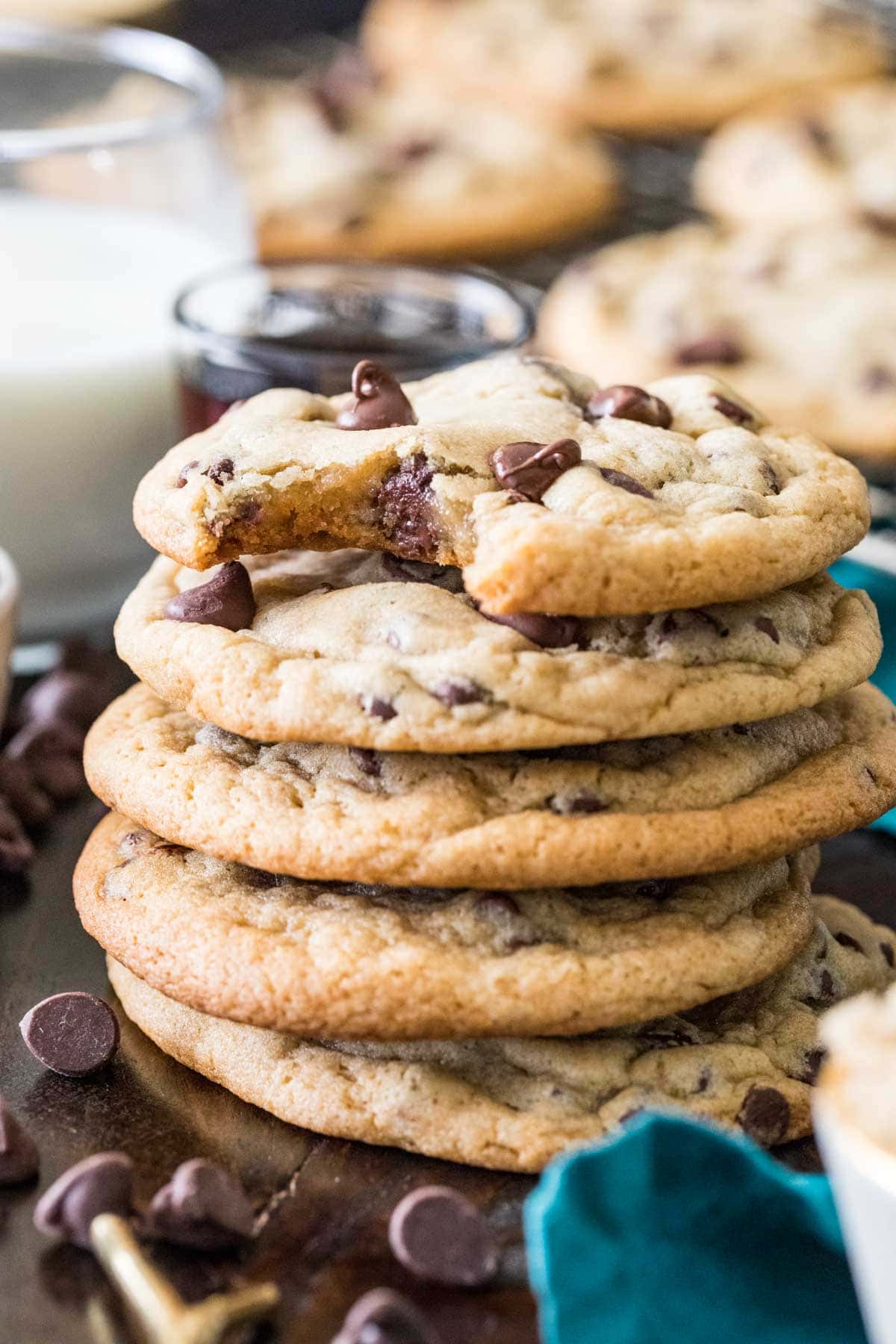 Stack of cookies made from this chocolate chip cookie recipe with melty chocolate chips and a bite missing from the top cookie