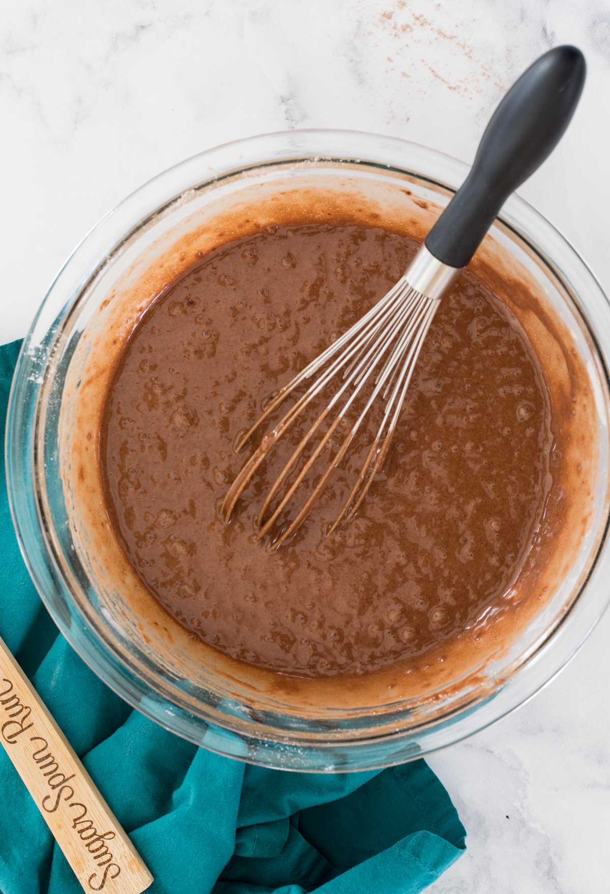 chocolate cake batter with whisk in glass bowl