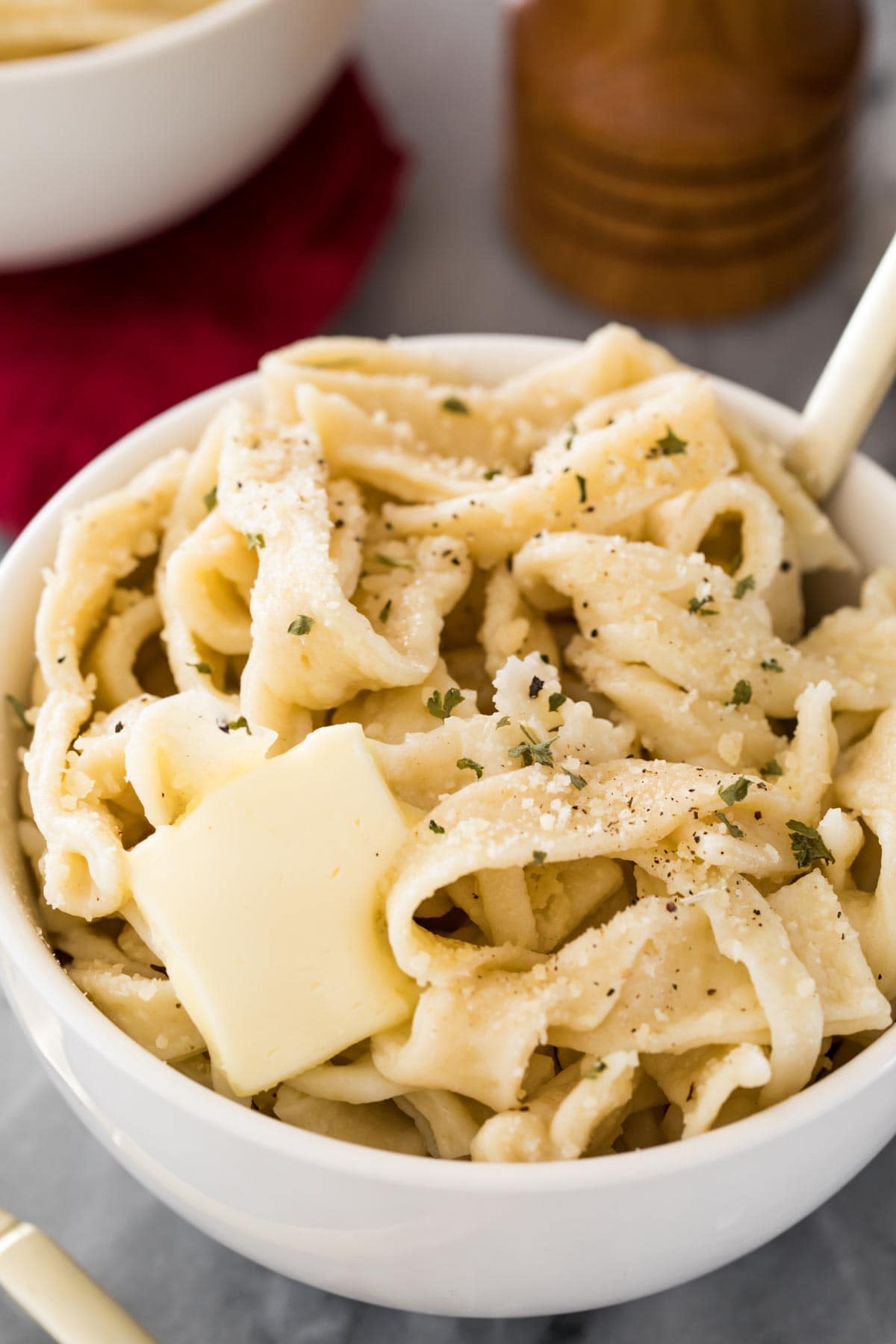 cooked egg noodles with butter in white bowl