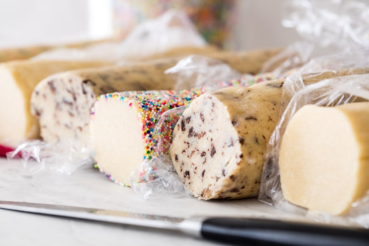 Multiple logs of icebox cookie dough with various mix-ins