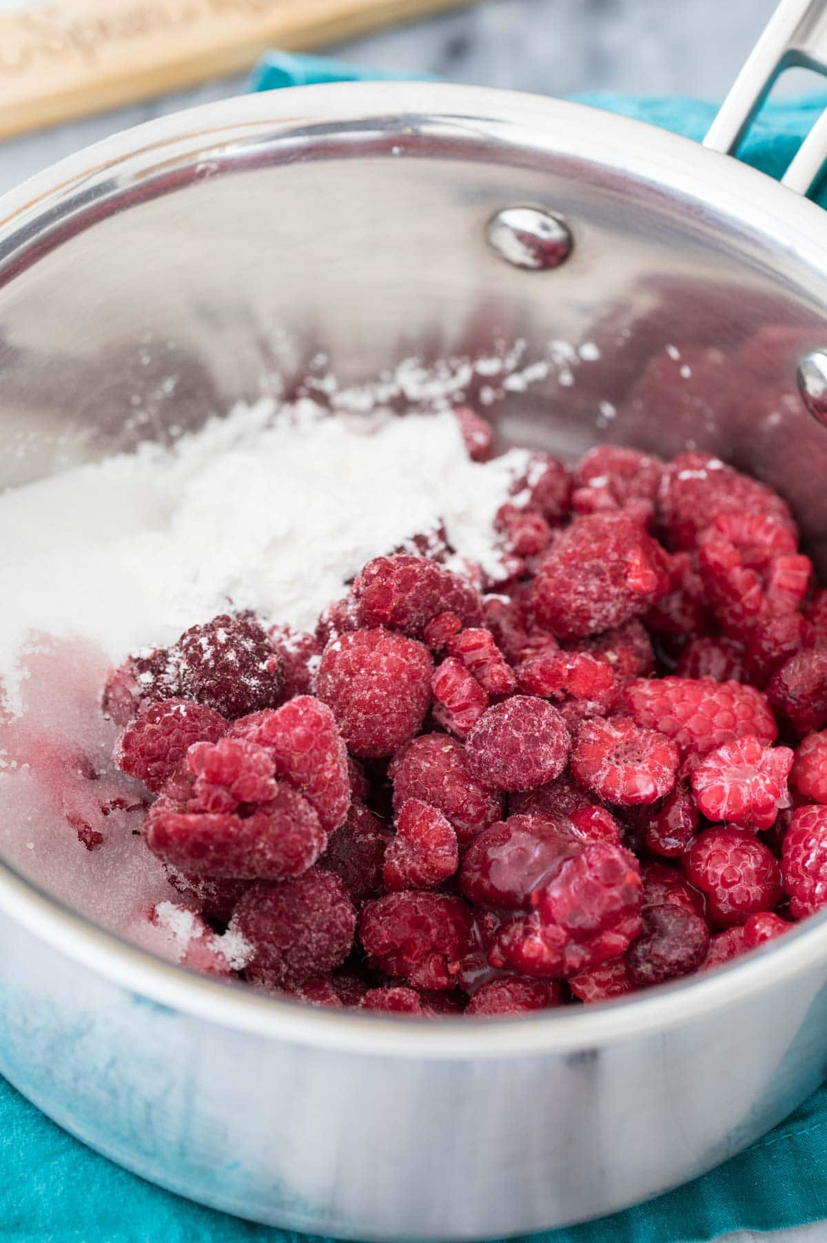 raspberries and sugar in silver-colored saucepan