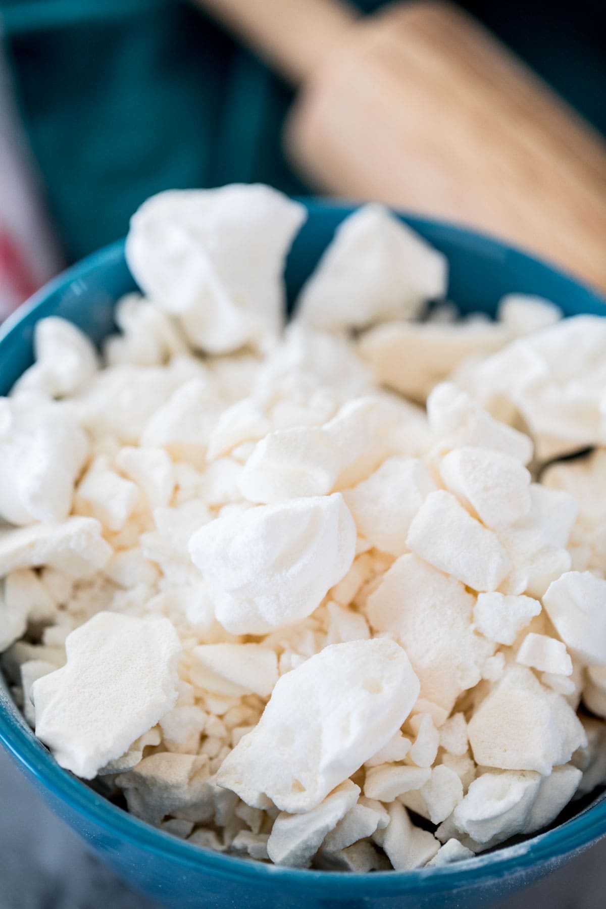 broken meringue cookies in blue bowl