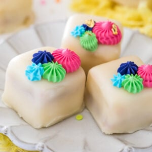 Petit fours on white plate with colorful frosting