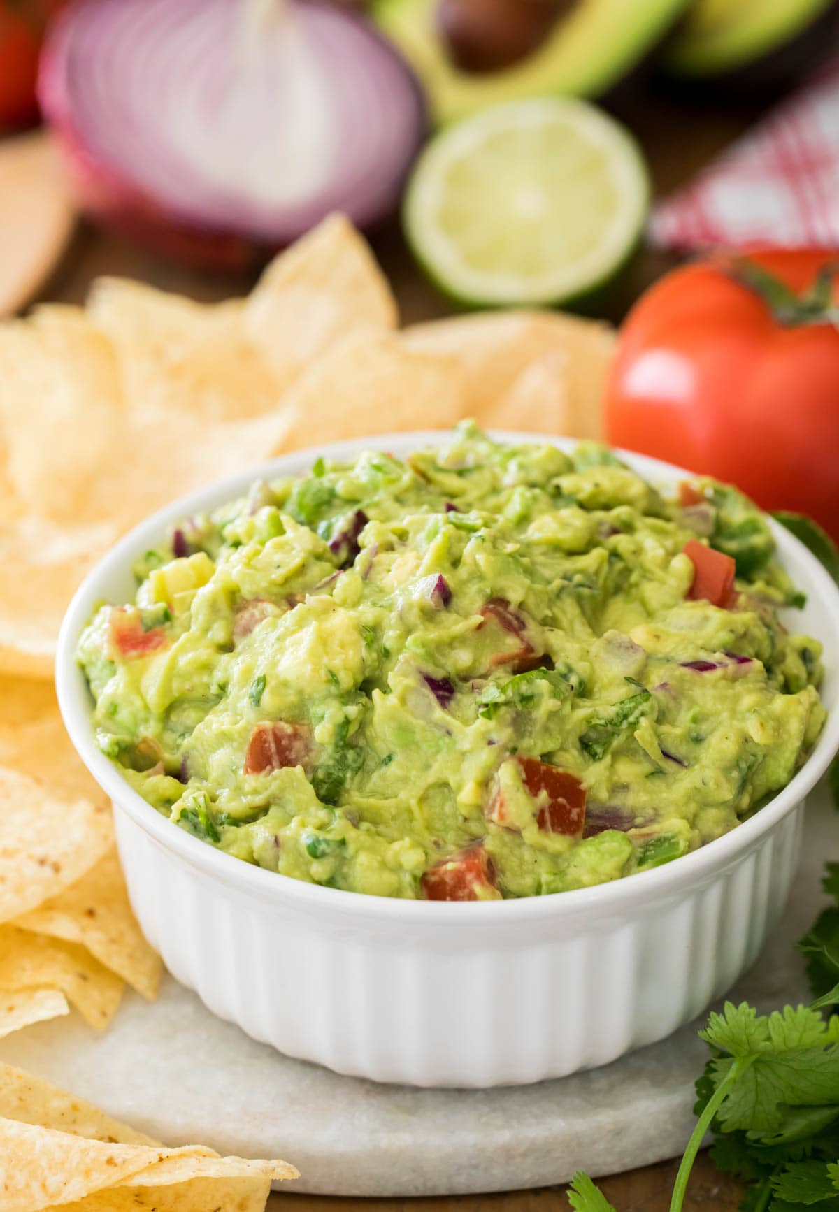 guacamole in white bowl surrounded by corn chips