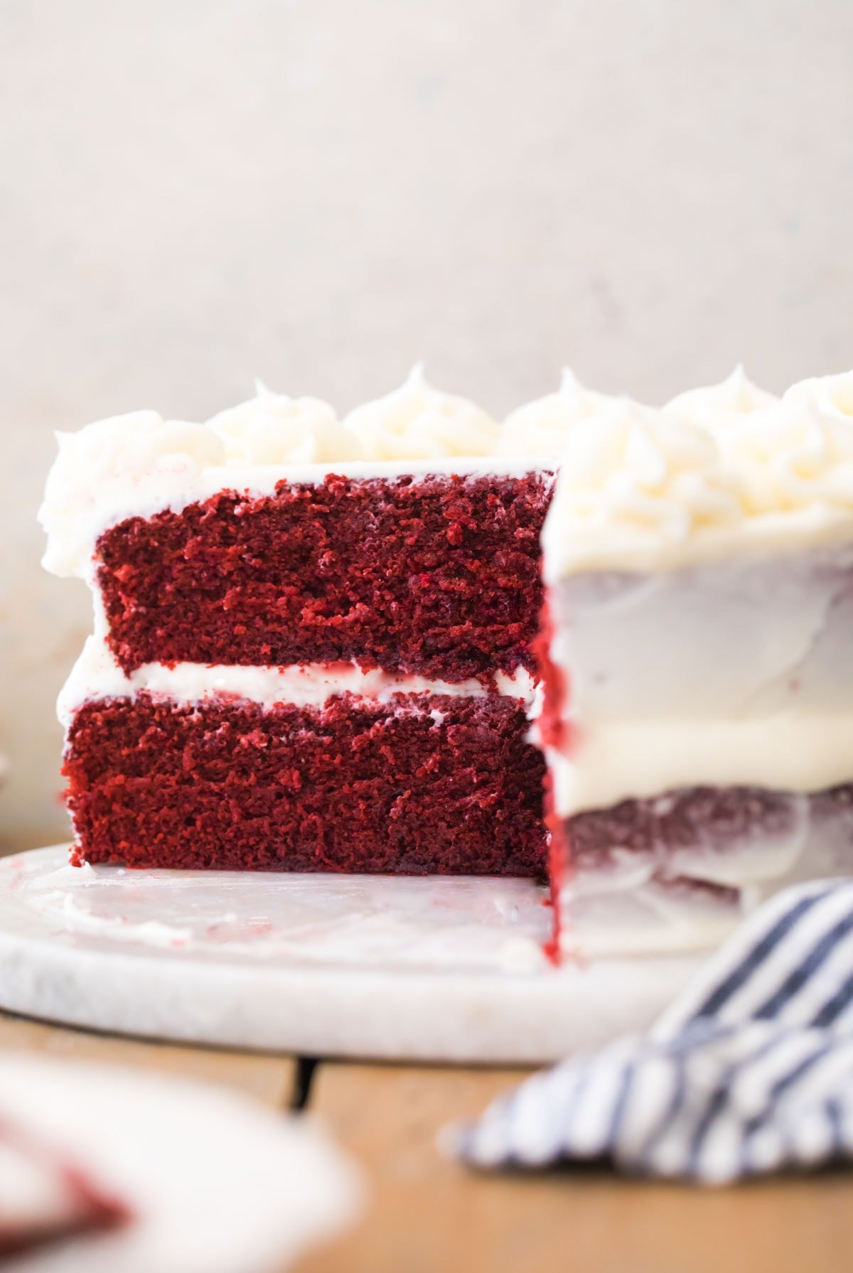 Red Velvet cake with slice missing on white marble