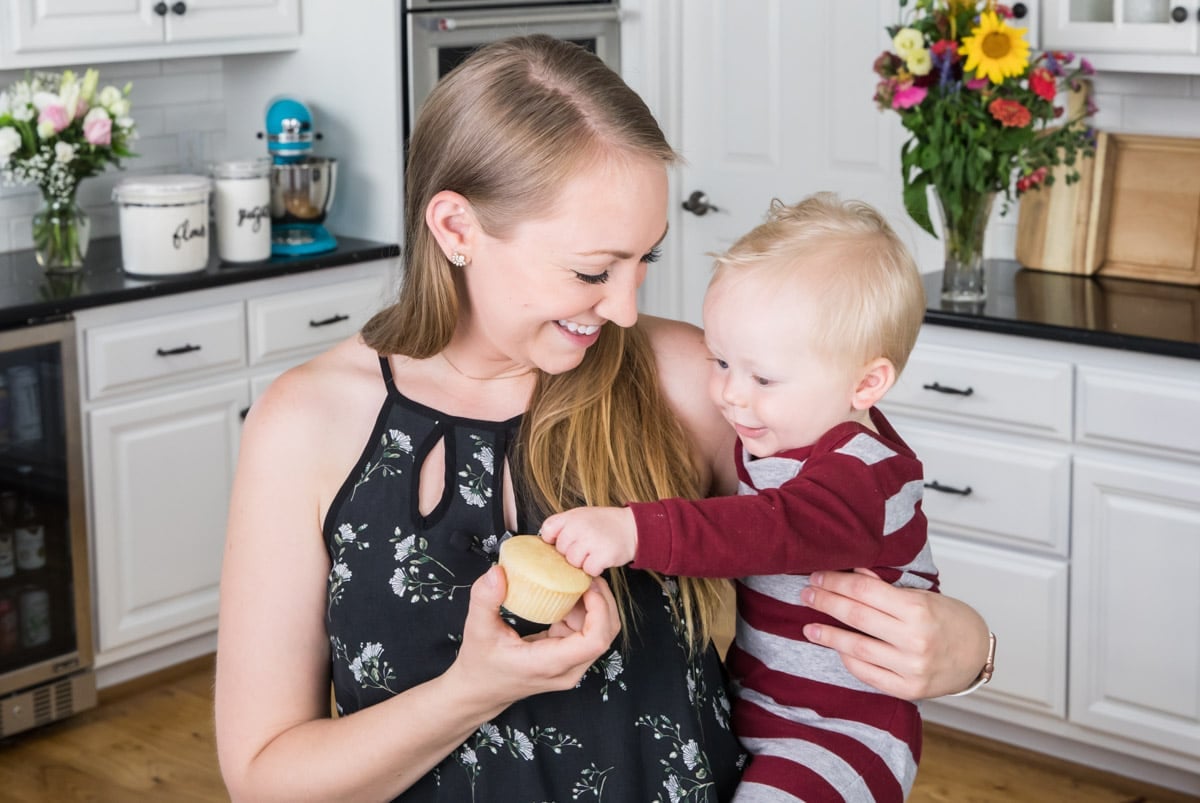 the author holding a cupcake with her baby