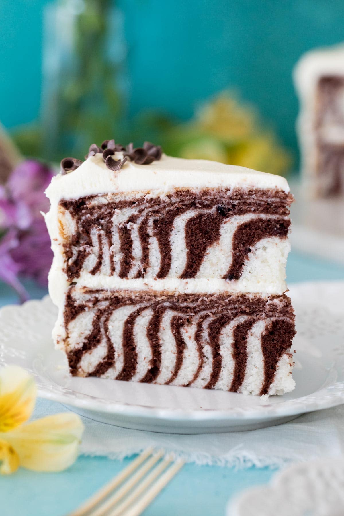 slice of striped zebra cake standing upright on white plate