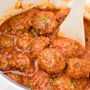 meatballs in pot with wooden spoon