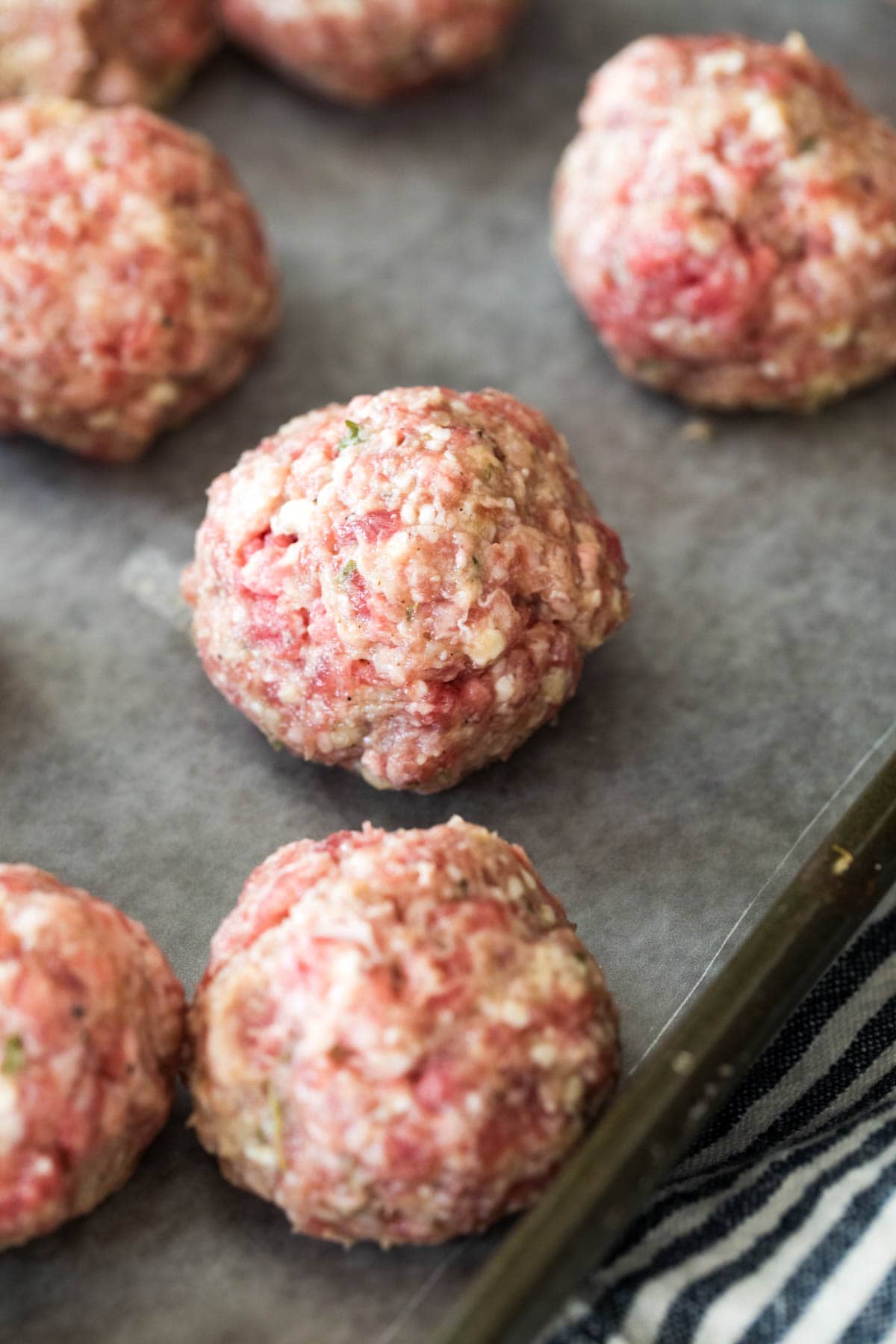 raw meatballs on baking sheet