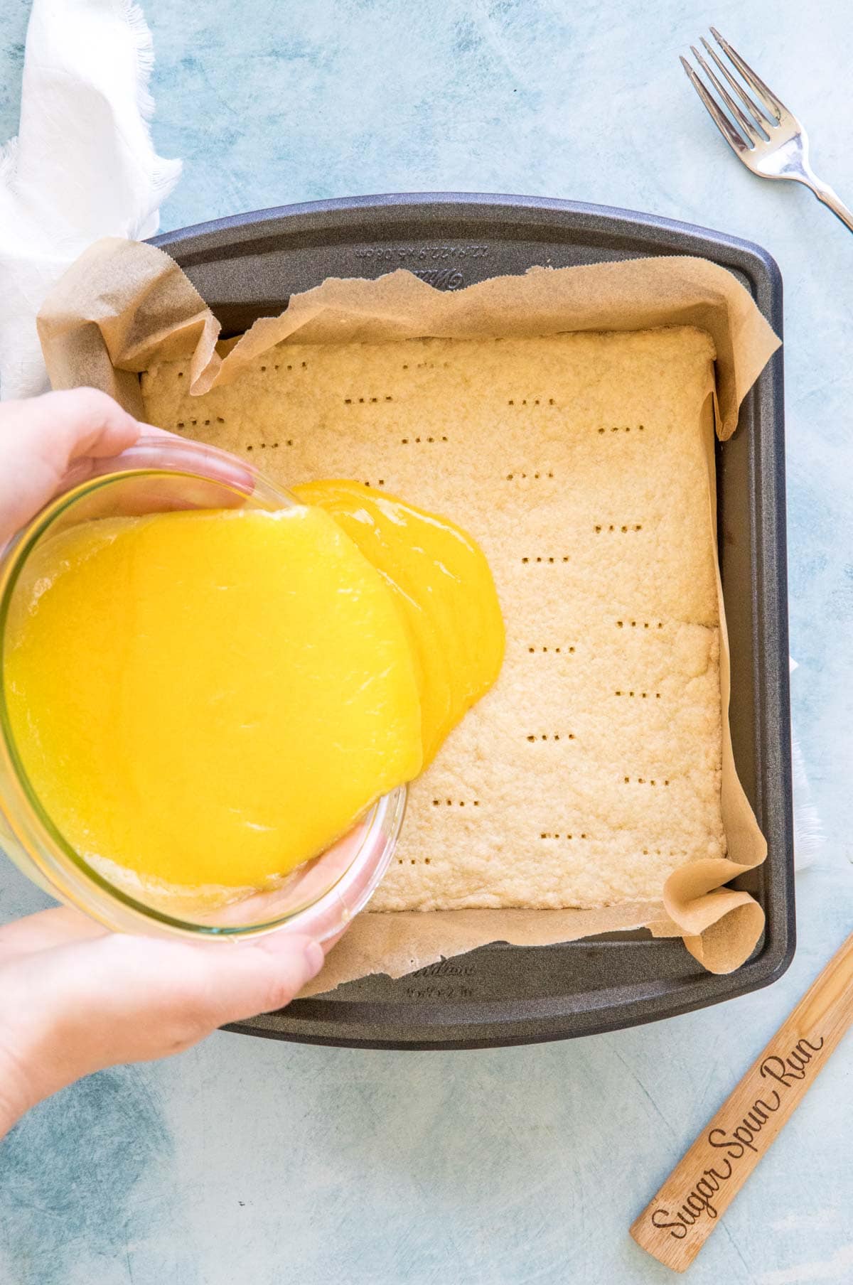 pouring lemon curd over shortbread crust