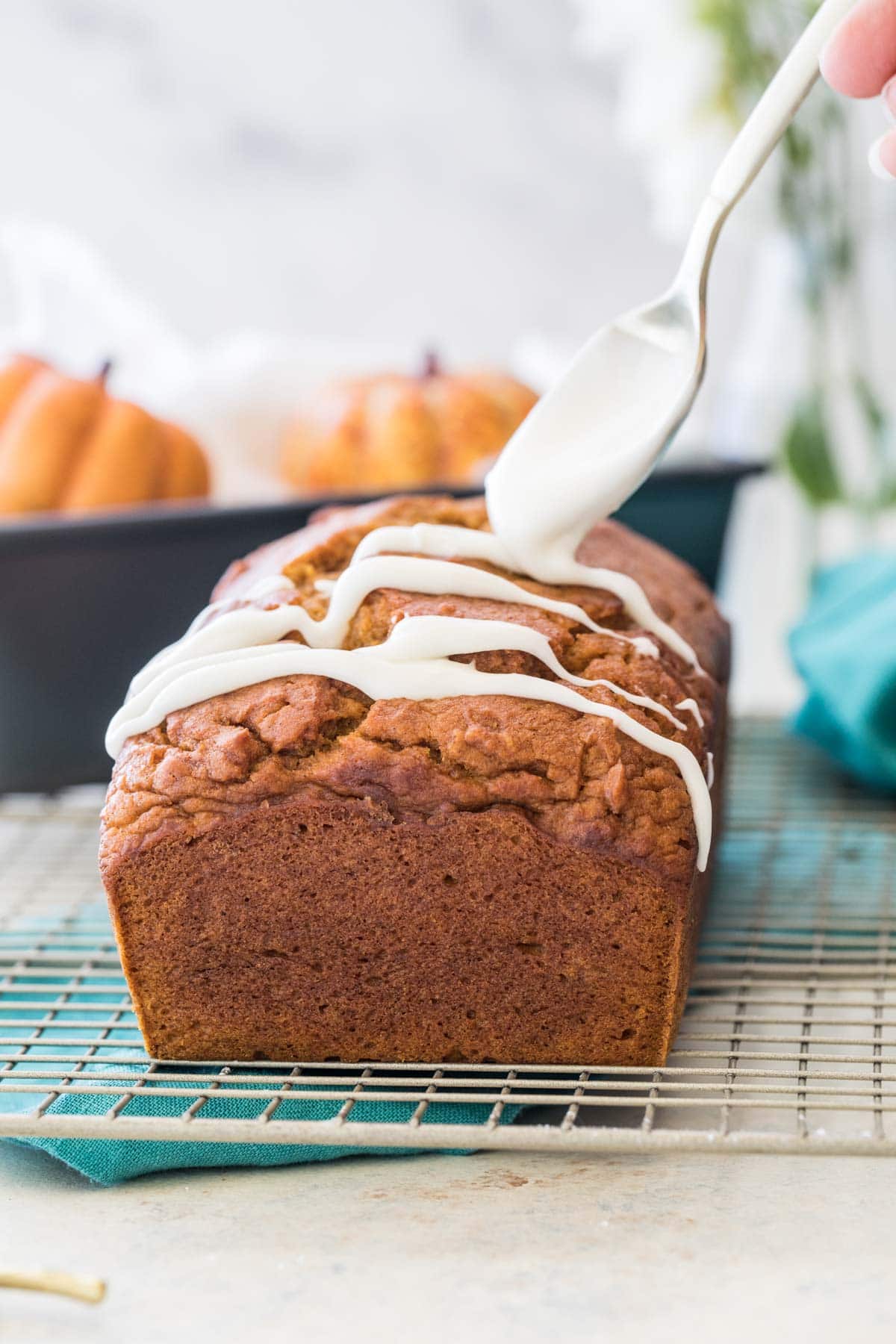 drizzling glaze over pumpkin loaf