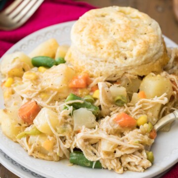 chicken pot pie with biscuit served on white plate