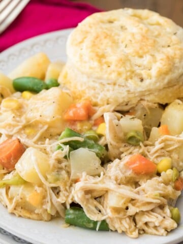 chicken pot pie with biscuit served on white plate