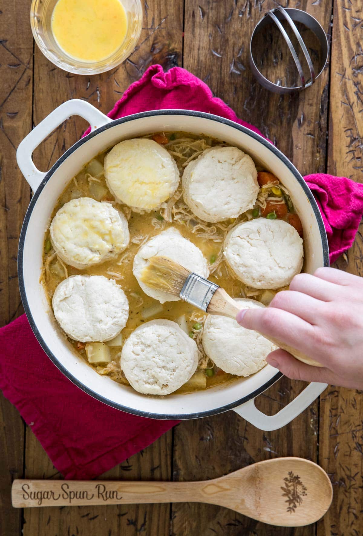 brushing egg over biscuits in pot