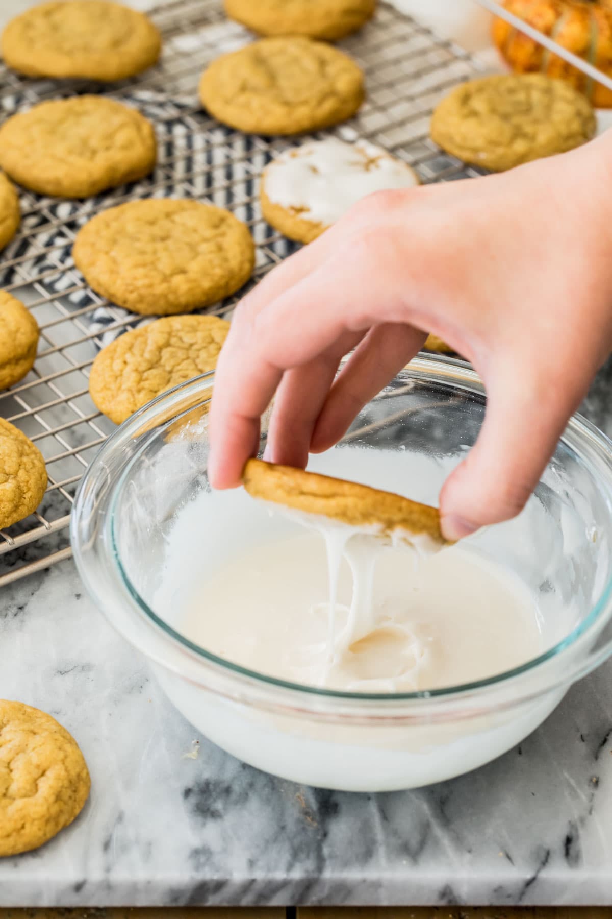 dipping cookie into glaze