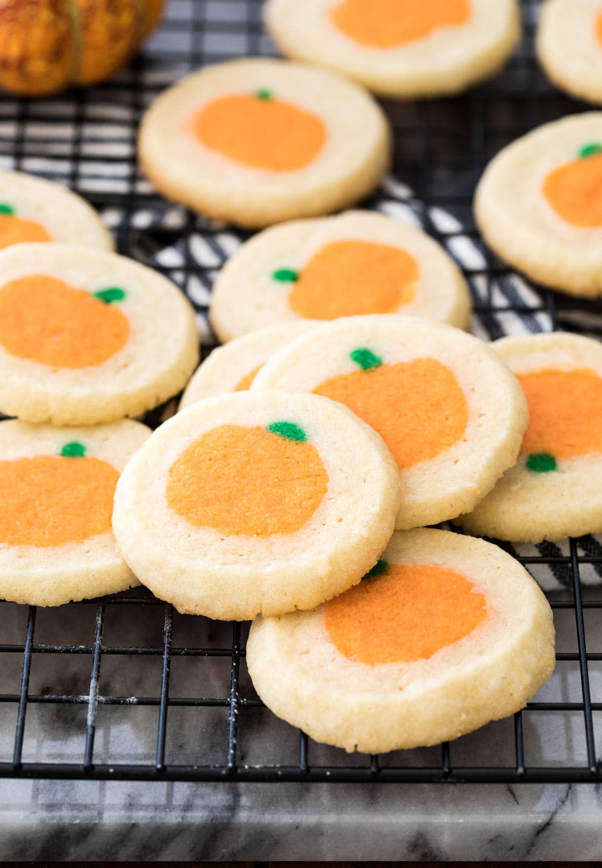 pumpkin sugar cookies on black cooling rack