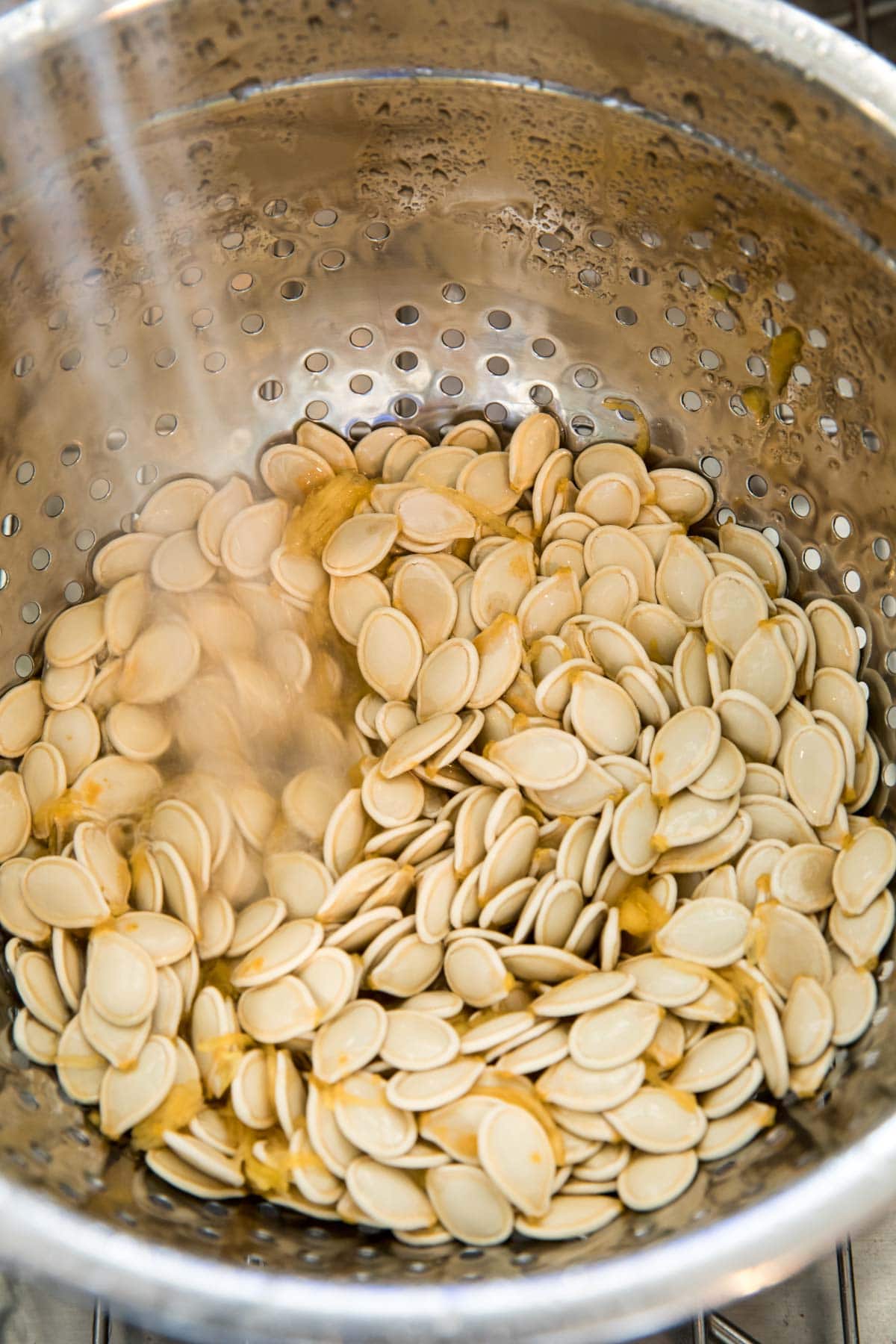 rinsing pumpkin seeds in colander