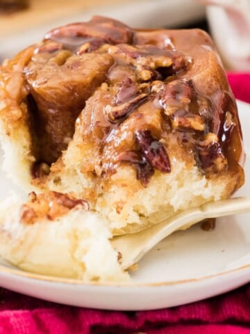 Sticky bun on white plate with fork