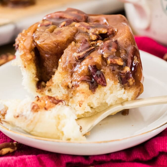 Sticky bun on white plate with fork