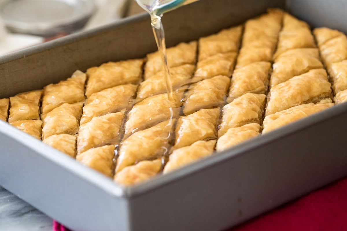 Pouring syrup over hot baklava