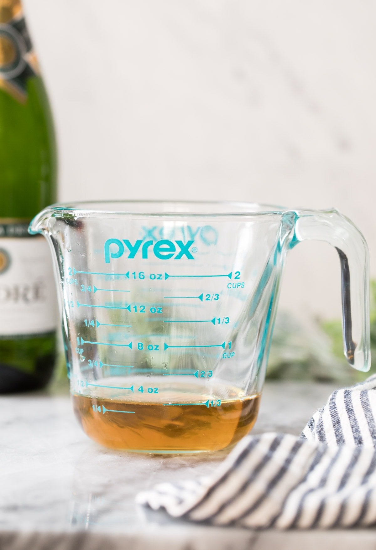 champagne that has been reduced in a blue measuring cup