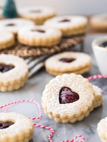 Linzer cookies on marble with red bakers twine
