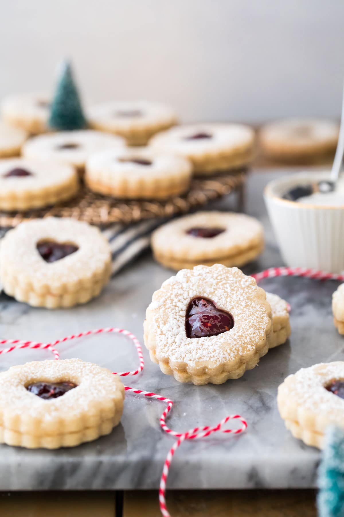 Linzer cookies on marble with red bakers twine