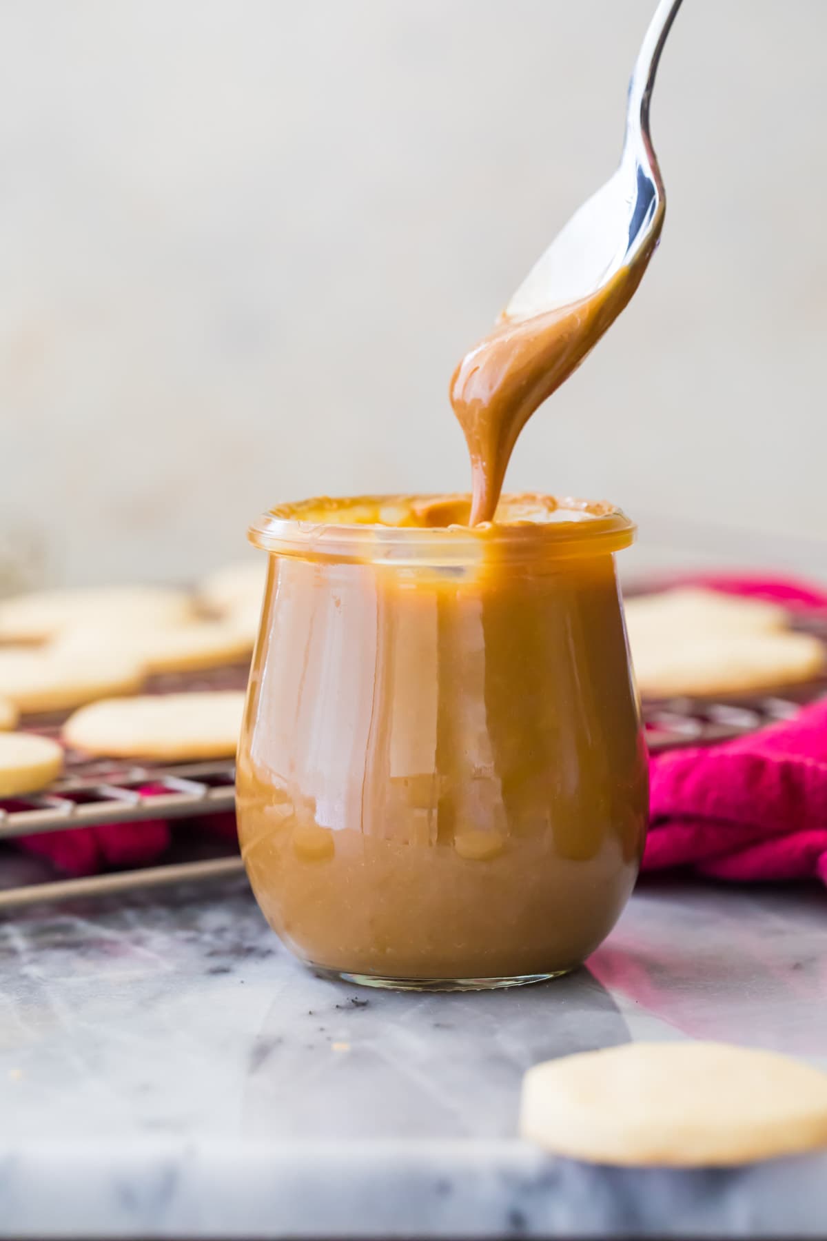 dipping spoon into jar of dulce de leche