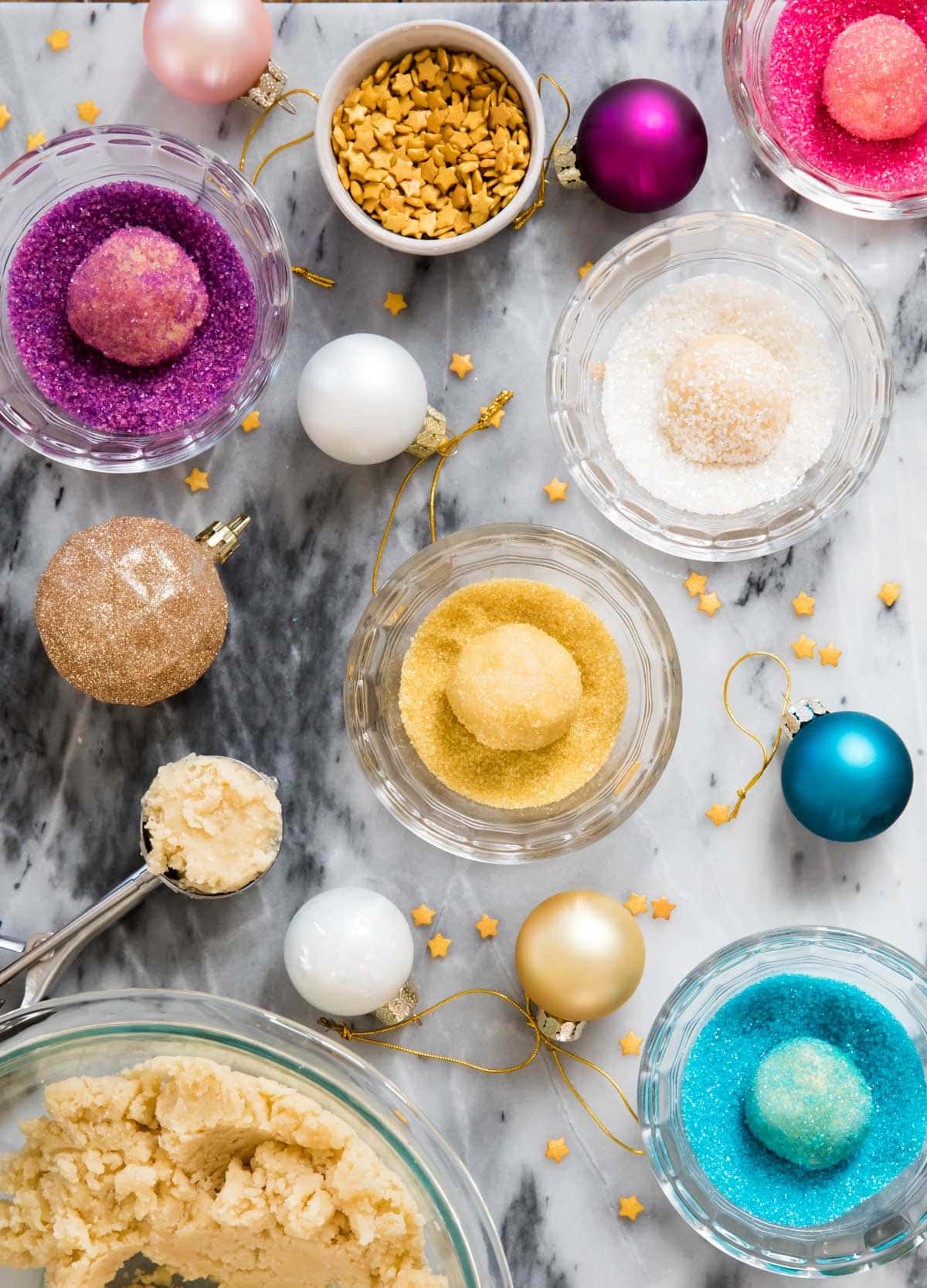 cookie dough rolled in bowls of colored sugar