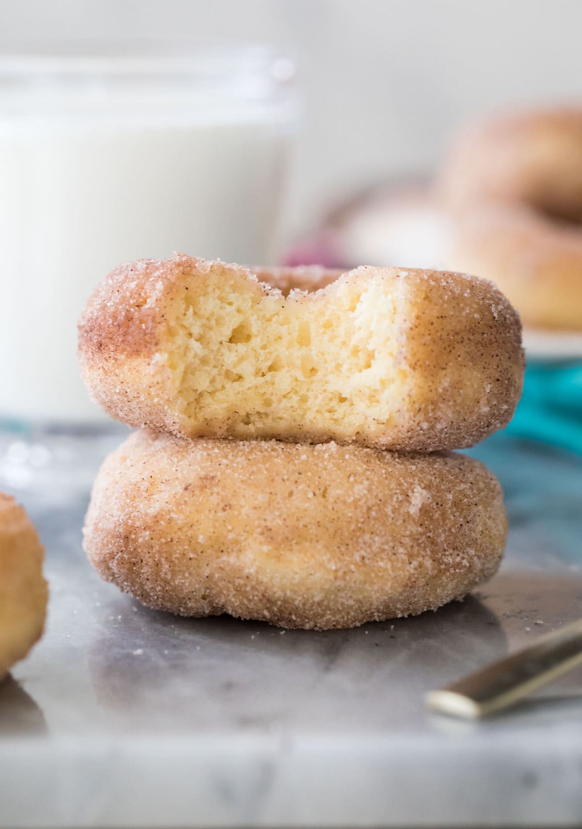 Two donuts stacked on top of each other, one with a bite missing