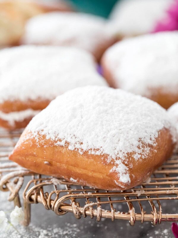 powder sugar-dusted beignet on cooling rack
