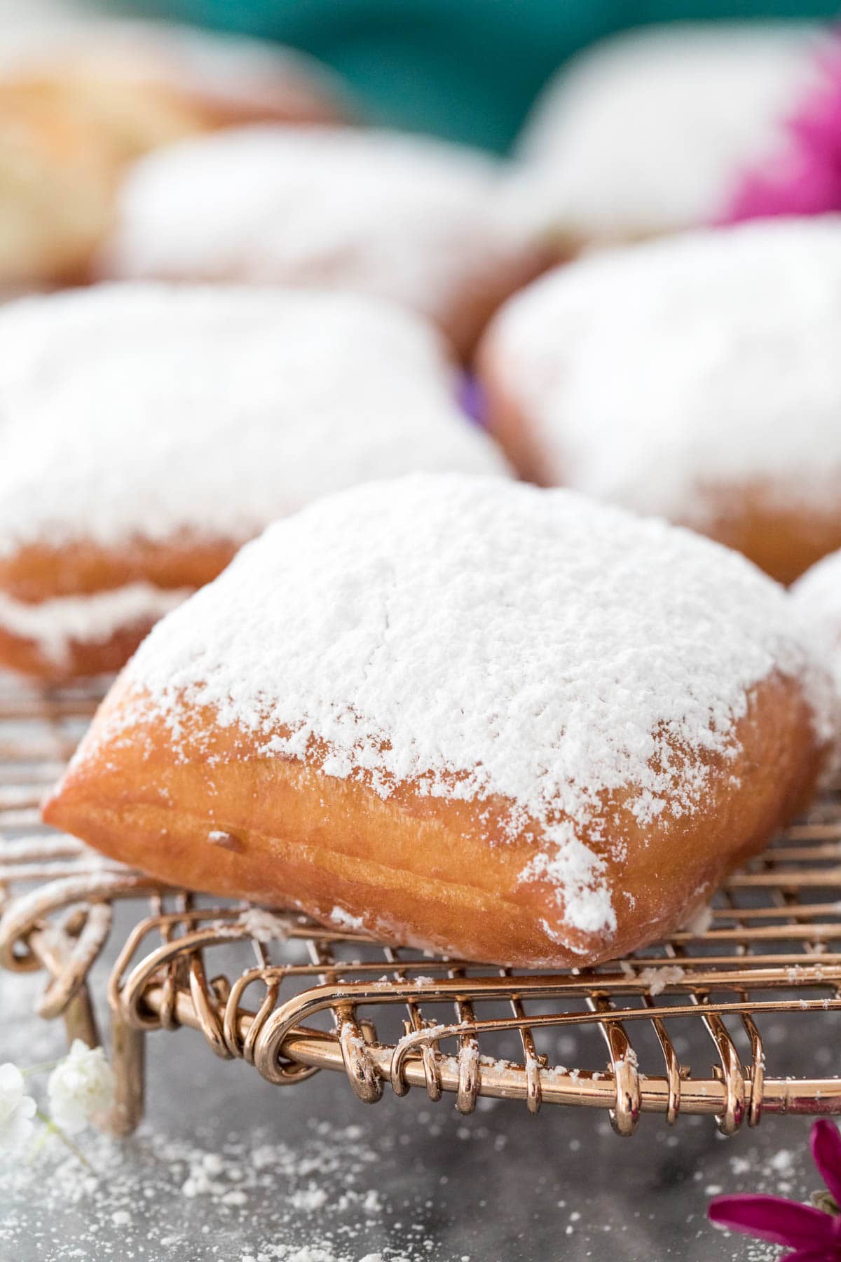 powder sugar-dusted beignet on cooling rack