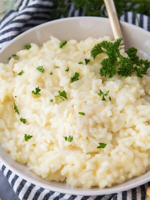 Creamy risotto in a white bowl sprinkled with parsley