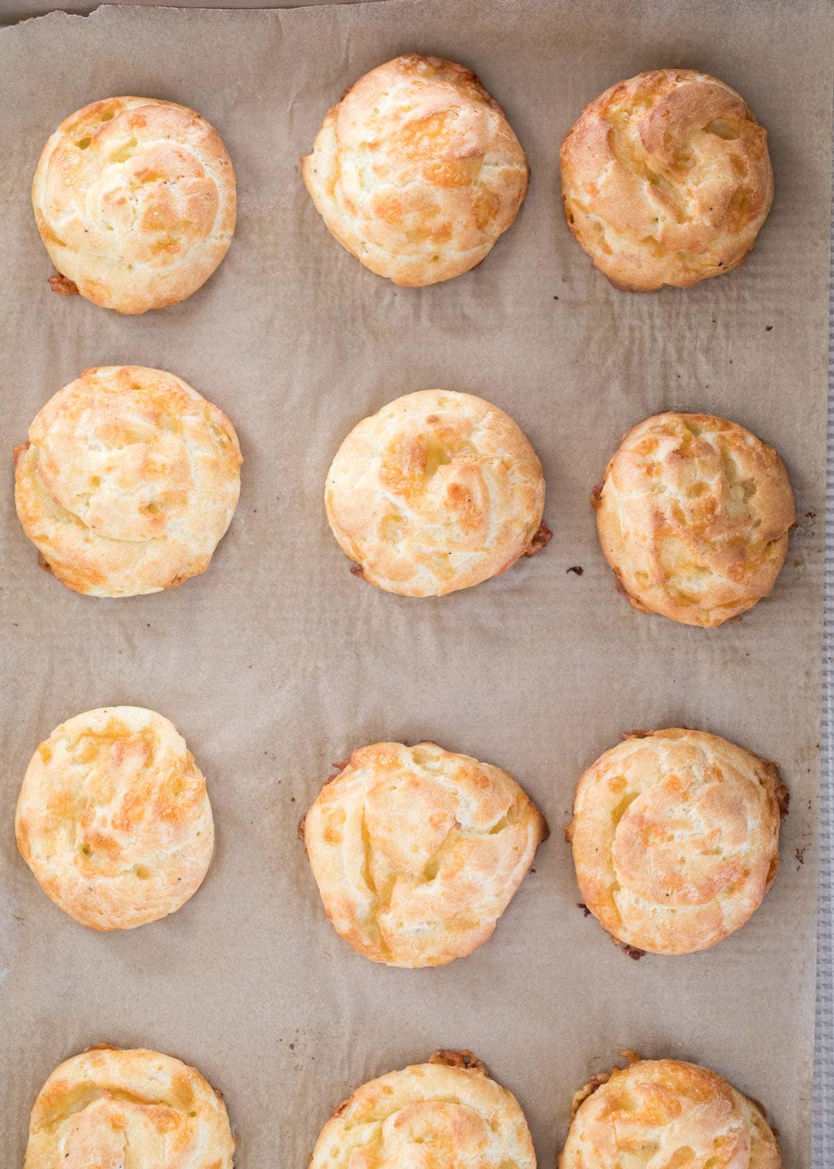 Gougeres on baking sheet after baking