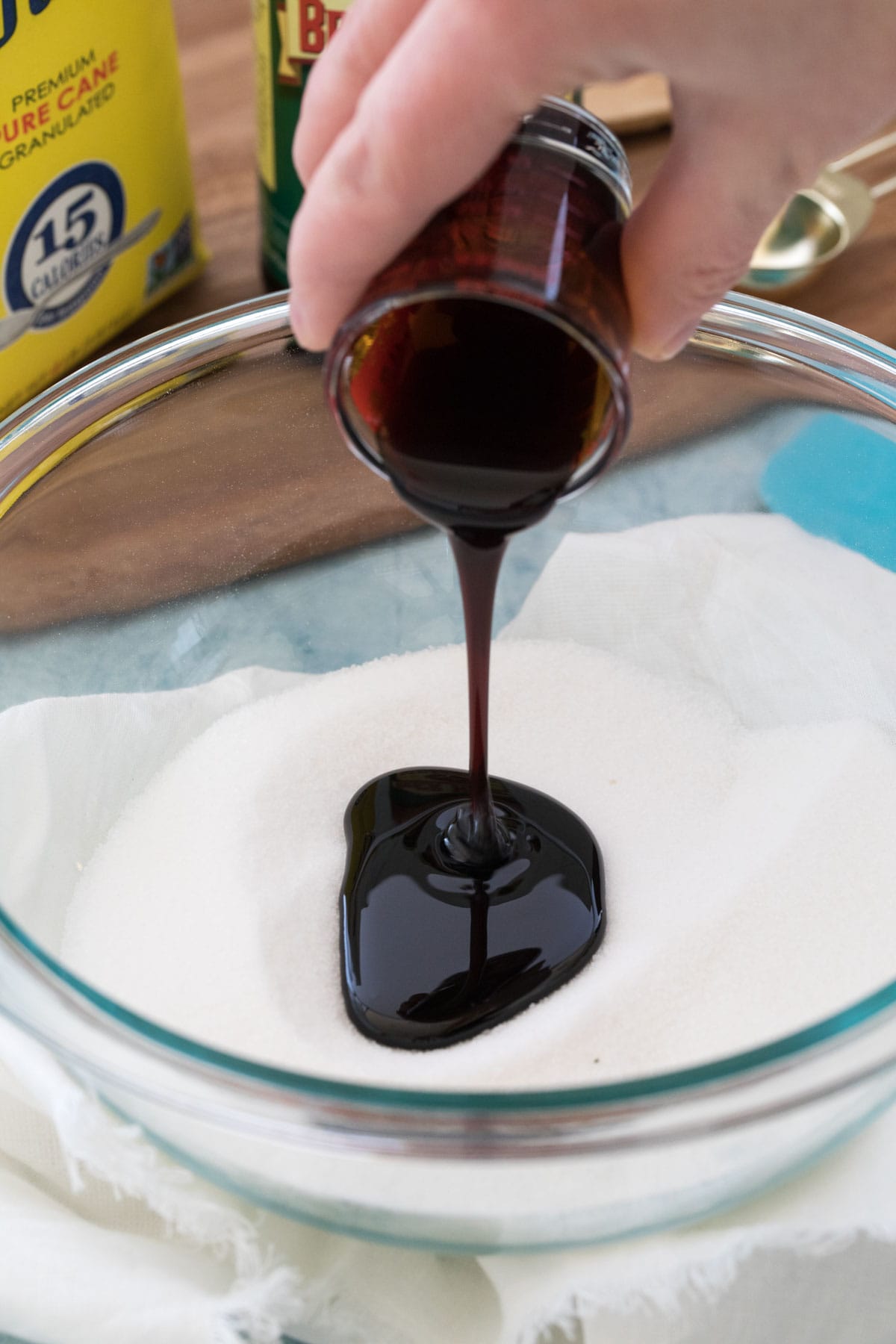 Pouring molasses into white sugar