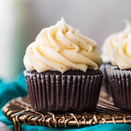 chocolate cupcake in a white liner topped with a pile of piped brown butter frosting