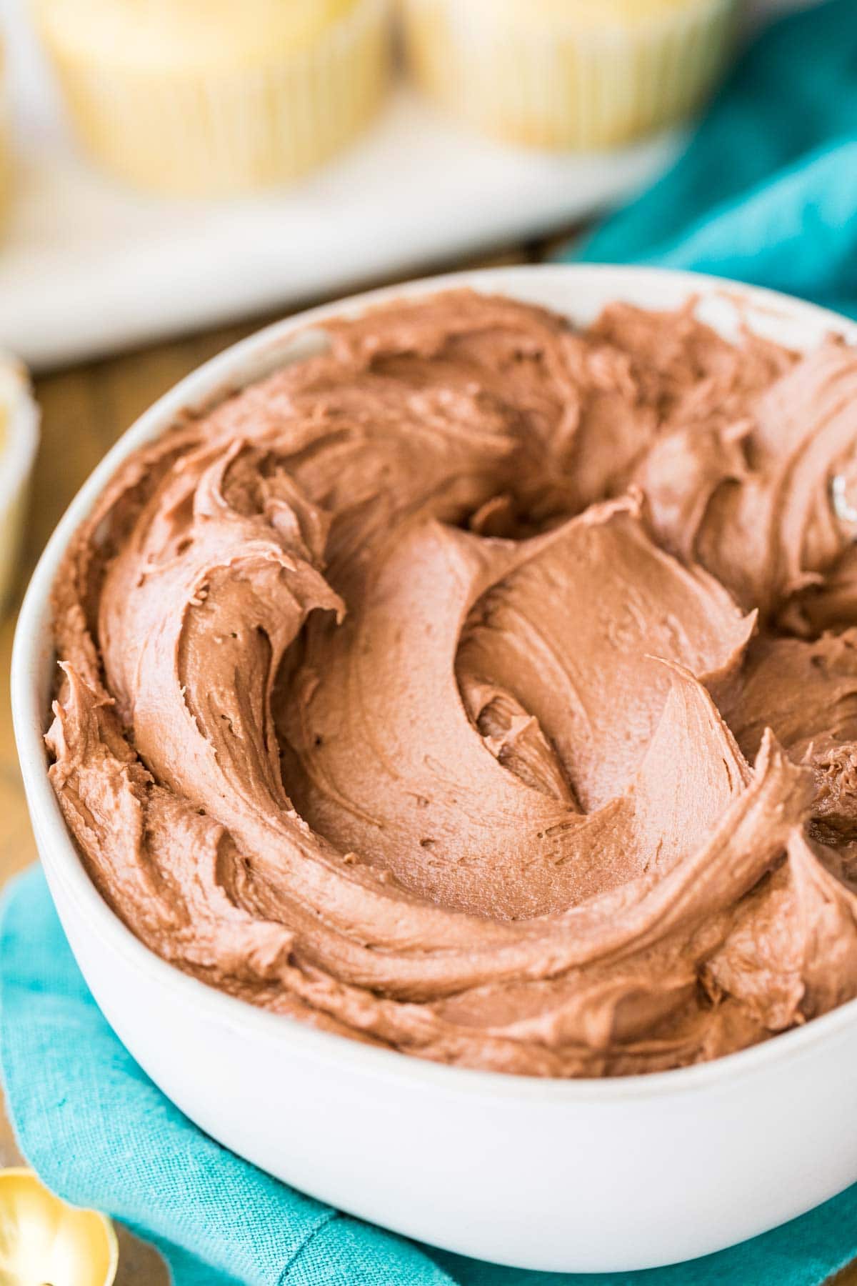 White bowl filled with chocolate frosting.