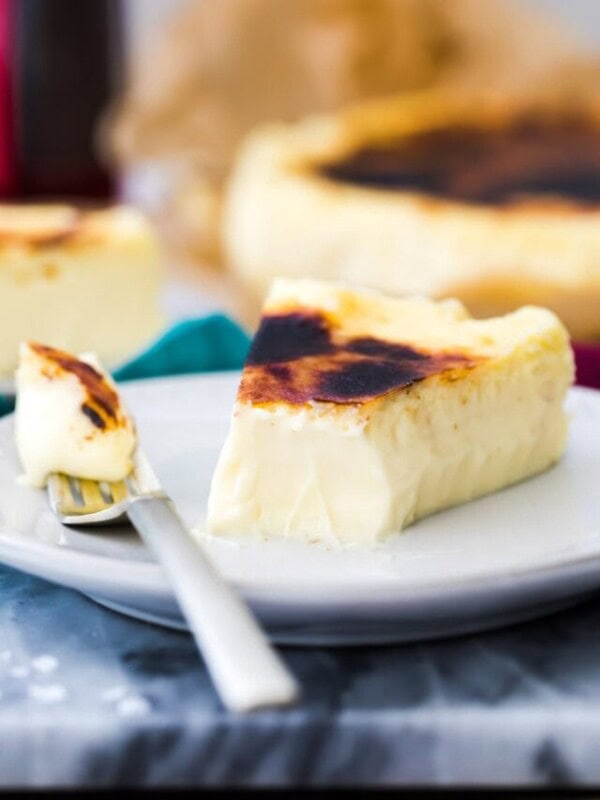 Basque cheesecake on white plate with bite taken out